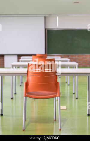 intérieur d'une salle de classe dans une école avec bureaux, chaises et tableau noir. lieu d'enseignement, arrière-plan Banque D'Images