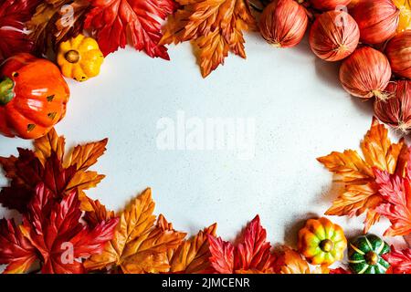 Cadre fait avec de fausses feuilles d'autumnl et de légumes de récolte sur le fond de béton Banque D'Images