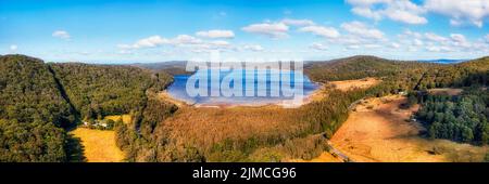 La route des lacs autour du lac Myall Parc national en Australie avec fermes agricoles dans les bois de gommiers - panorama aérien. Banque D'Images