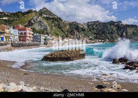 Surf en bord de mer en face de la promenade avec Taormina sur la colline, Giardini-Naxos, côte est, Sicile, Italie Banque D'Images