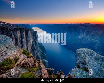 Rock face de Kjerag au-dessus du Lysefjord au crépuscule, Lyseboten, Rogaland, Norvège Banque D'Images