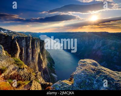 Rock face de Kjerag au-dessus du Lysefjord dans la lumière du soir, Lyseboten, Rogaland, Norvège Banque D'Images