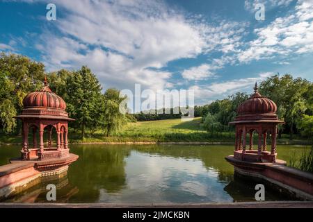 Deux pagodas rouges (Srila Prabhupada Puspa Samadhi) dans un lac, soleil dans la vallée de Krishna-voelgy Parolo Paroisse, Somogyvamos, Balaton Banque D'Images