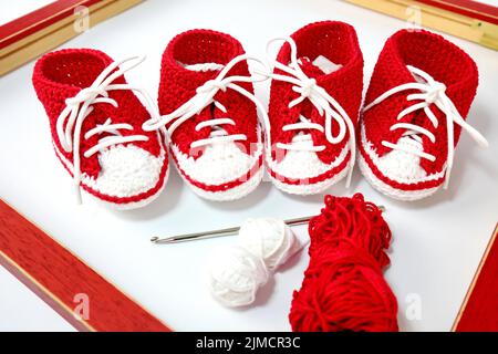 Chaussures bébé ou chaussures en crochet en rouge et blanc isolées sur fond blanc Banque D'Images