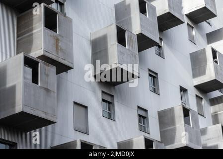 De l'extérieur inférieur de la maison résidentielle avec des fenêtres et divers balcons gris situés sur la rue de la ville Banque D'Images
