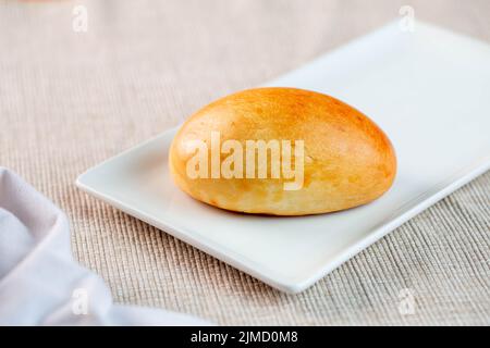 Un délicieux petit pain fraîchement cuit servi sur une assiette rectangulaire le matin à la maison Banque D'Images