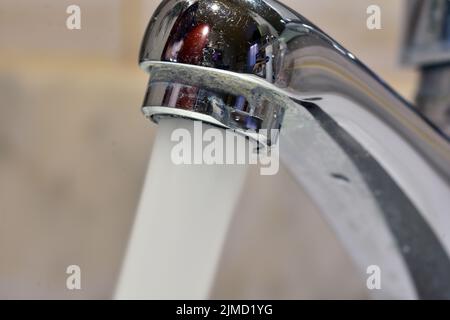 Chorro de agua cayendo de un grifo de un lavabo Banque D'Images