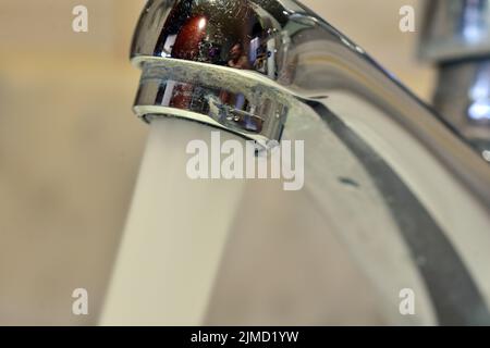 Chorro de agua cayendo de un grifo de un lavabo Banque D'Images