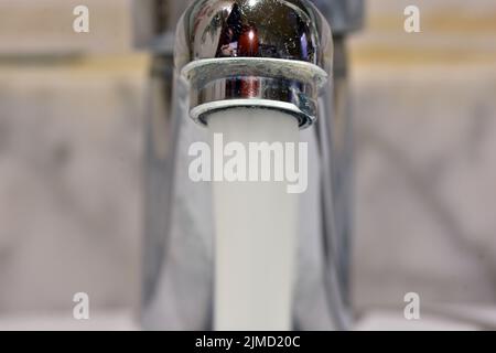 Chorro de agua cayendo de un grifo de un lavabo Banque D'Images