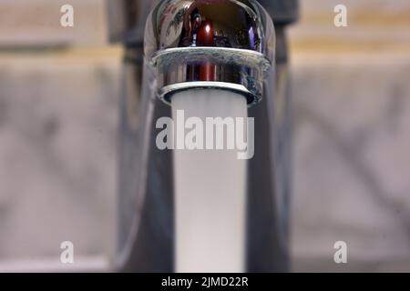 Chorro de agua cayendo de un grifo de un lavabo Banque D'Images