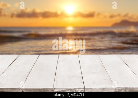 Videz les planches de bois blanches ou le comptoir contre un paysage marin avec coucher de soleil sur l'arrière-plan. Modèle, maquette pour affichage ou montage de p Banque D'Images