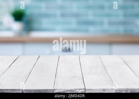 Videz les planches blanches en bois ou le dessus de table sur l'intérieur flou de la cuisine sur fond. Modèle, maquette pour affichage ou montage. CLO Banque D'Images