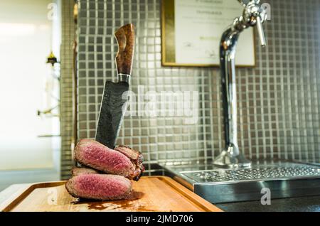 Belle photo de poitrine de boeuf (Brisket point fin). Découpe de viande avec un couteau en acier forgé de Damas Arkan Banque D'Images