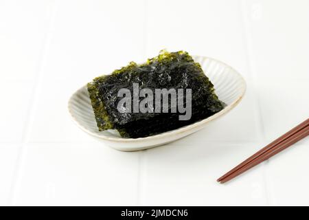 Feuille de Nori Laver croustillante salée sur plaque blanche, populaire au Japon et en Corée pour les sushis et les kimbap. Copier l'espace pour le texte Banque D'Images