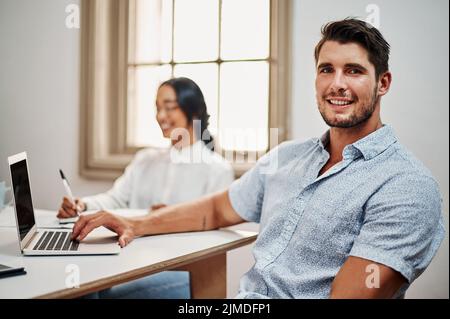 Nous voulons le succès et nous allons l'obtenir. Portrait d'un jeune homme d'affaires ayant une réunion avec des collègues dans un bureau moderne. Banque D'Images