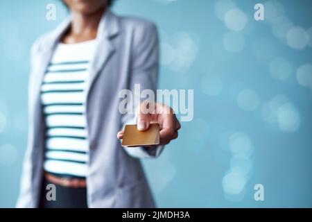Main de la femme tenant une carte de crédit pour les opérations bancaires, les achats et les achats tout en restant isolée sur l'espace de copie bleu. Doigts d'une femme africaine élégante Banque D'Images