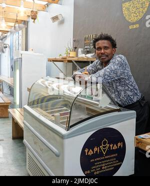 Kapstadt, Afrique du Sud. 26th juillet 2022. Tapiwa Guzha se trouve dans son glacier TAPI TAPI. Le biologiste moléculaire a inventé plus de 600 variétés de glace inhabituelles dans la métropole touristique du Cap. Tapiwa Guzha aime jouer avec de nouvelles combinaisons de saveurs. (À dpa 'poisson et argile: Curieuse tendance de la glace au Cap') Credit: Kristin Palitza/dpa/Alamy Live News Banque D'Images