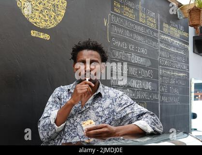 Kapstadt, Afrique du Sud. 26th juillet 2022. Tapiwa Guzha se trouve dans son glacier TAPI TAPI. Le biologiste moléculaire a inventé plus de 600 variétés de glace inhabituelles dans la métropole touristique du Cap. Tapiwa Guzha aime jouer avec de nouvelles combinaisons de saveurs. (À dpa 'poisson et argile: Curieuse tendance de la glace au Cap') Credit: Kristin Palitza/dpa/Alamy Live News Banque D'Images