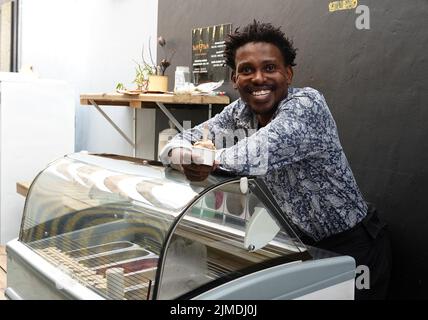 Kapstadt, Afrique du Sud. 26th juillet 2022. Tapiwa Guzha se trouve dans son glacier TAPI TAPI. Le biologiste moléculaire a inventé plus de 600 variétés de glace inhabituelles dans la métropole touristique du Cap. Tapiwa Guzha aime jouer avec de nouvelles combinaisons de saveurs. (À dpa 'poisson et argile: Curieuse tendance de la glace au Cap') Credit: Kristin Palitza/dpa/Alamy Live News Banque D'Images