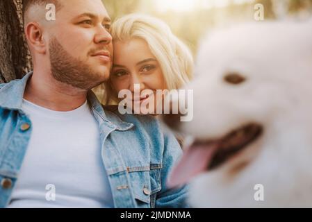 Un couple heureux avec un chiot de race samoyed profite de son week-end Banque D'Images