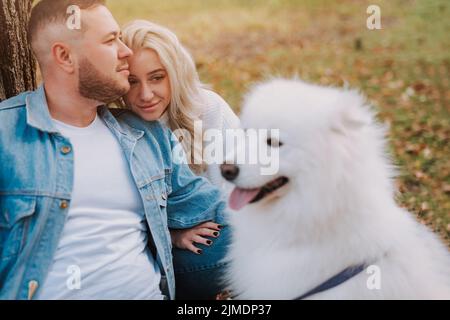 Un couple avec un chiot de race samoyed profite de son week-end Banque D'Images