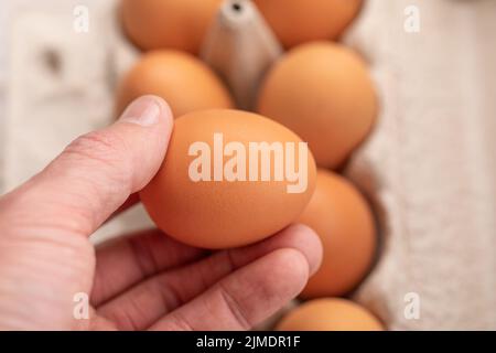Œuf à la main et fond d'œuf pour la cuisson de la mise au point douce. Banque D'Images