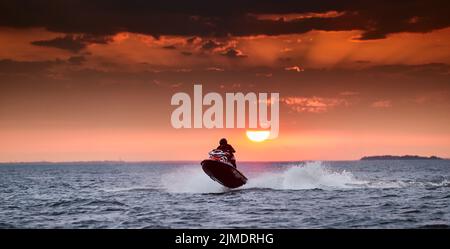 Russie, Saint-Pétersbourg, 06 septembre 2020:la personne sur un hydrocycle en vol sur l'eau au coucher du soleil, éclabousse sous un hydr Banque D'Images