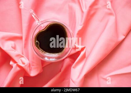 une tasse de café en forme de coeur sur une table sur une nappe, café du matin et romance Banque D'Images