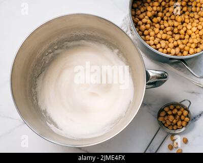 Aquafaba aux pois chiches fouettés dans un bol de batteur planétaire Banque D'Images