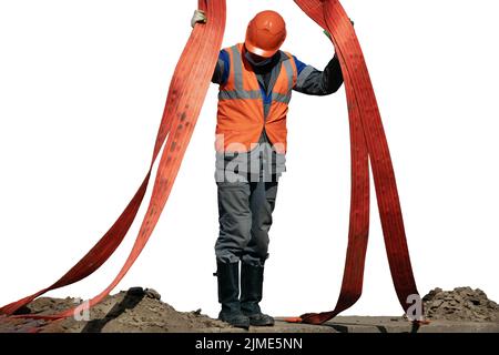 Une élingue dans un casque et une salopette décharge la charge à l'aide d'élingues. Un homme au travail dans la production. Banque D'Images