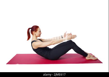 Exercice Pilates retour. Une femme élancée effectue un exercice pour renforcer et étirer son dos et sa colonne lombaire. Banque D'Images