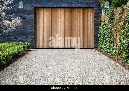 Grande porte de garage et allée en béton à l'avant Banque D'Images