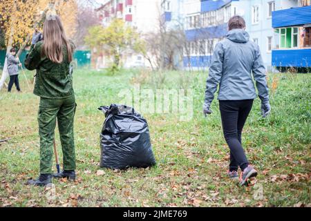 Récolte de feuilles sèches dans le jardin. Le travail du jardinier. Banque D'Images