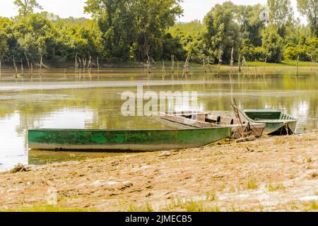 Une vue sur l'arrière-plan du Danube illuminé par le soleil. Bateaux en bois pour la pêche sportive amarrés sur la rive de l'eau de la branche du Danube dans le TH Banque D'Images