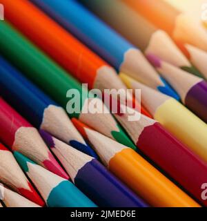 Les crayons de couleur aiguisés se trouvent dans une rangée de gros plan. Arrière-plan abstrait Uni de crayons multicolores en bois. Banque D'Images