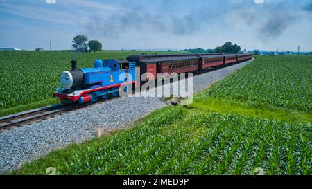 Vue aérienne de Thomas le moteur de réservoir approchant de tirer des voitures de tourisme soufflant de la fumée Banque D'Images