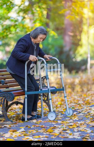 Femme avec walker walking outdoors Banque D'Images