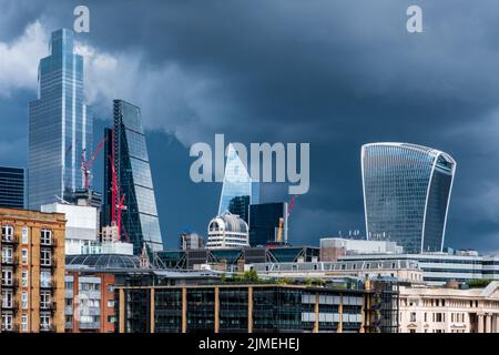 Quartier des affaires de la ville de Londres, gratte-ciels éclatants, dans un ciel de tempête spectaculaire. Banque D'Images