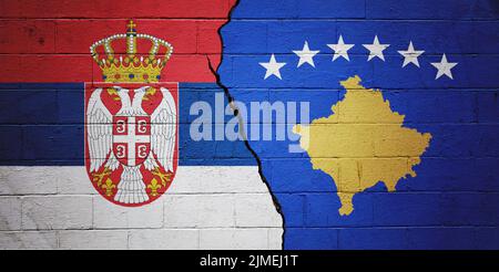 Mur de briques fissuré peint avec un drapeau de la Serbie à gauche et un drapeau du Kosovo à droite.