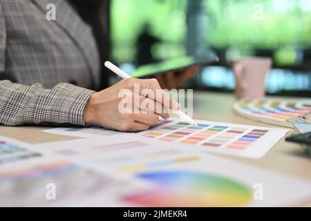Vue rognée d'une décoratrice d'intérieur féminine travaillant avec des nuances de couleurs au bureau dans un bureau créatif Banque D'Images
