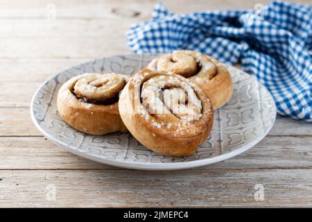 Petits pains à la cannelle. Dessert suédois Kanelbulle sur une table en bois Banque D'Images