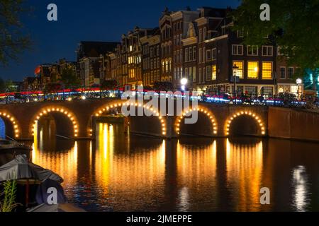 Canal d'Amsterdam la nuit et pont illuminé Banque D'Images