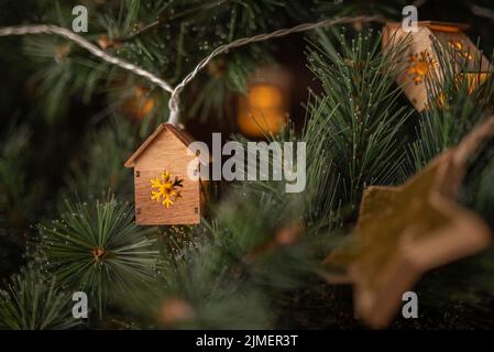 En hiver, vue sur la guirlande des arbres de noël sous forme de petites maisons et étoile dorée. Banque D'Images