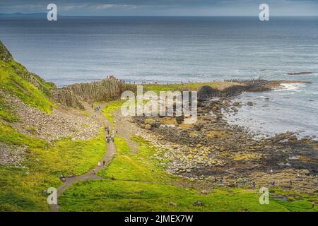 Touristes sur la principale formation de roche hexagonale à Giants Causeway, Irlande du Nord Banque D'Images