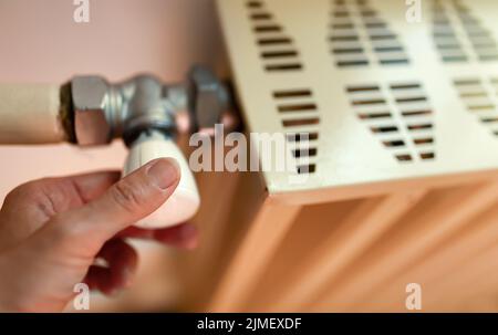 Rotation manuelle, réglage d'un ancien radiateur de chauffage. Économie de gaz, crise énergétique, saison de chauffage. Banque D'Images