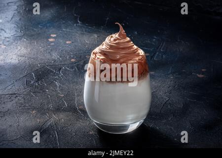 Café froid Dalgona sur fond noir. Boisson coréenne douce Banque D'Images
