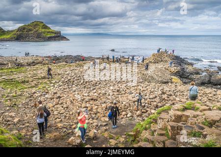 Touristes photographiant la formation de roche hexagonale à Giants Causeway, patrimoine mondial de l'UNESCO Banque D'Images