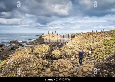 Touristes visitant la formation de roche hexagonale à Giants Causeway, Wild Atlantic Way Banque D'Images