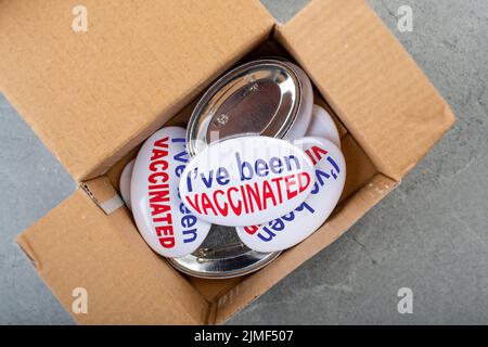 Boutons de la campagne de vaccination dans la boîte en carton sur la table en pierre, vue à plat Banque D'Images