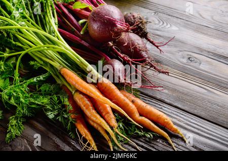 Betteraves et carottes bio frais sur table rustique en bois cuisine vue rapprochée Banque D'Images